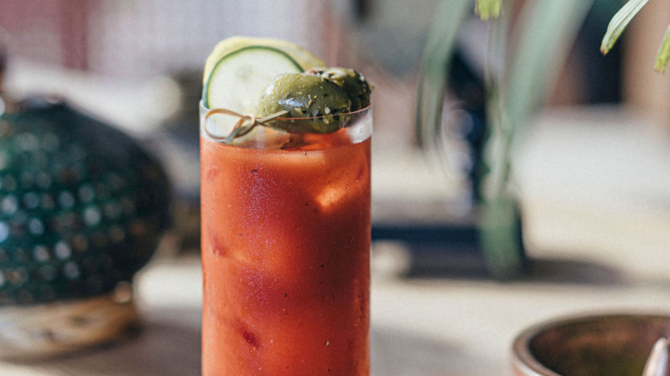 Zapote Bar cocktail in tom collins glass with lime garnish on bar
